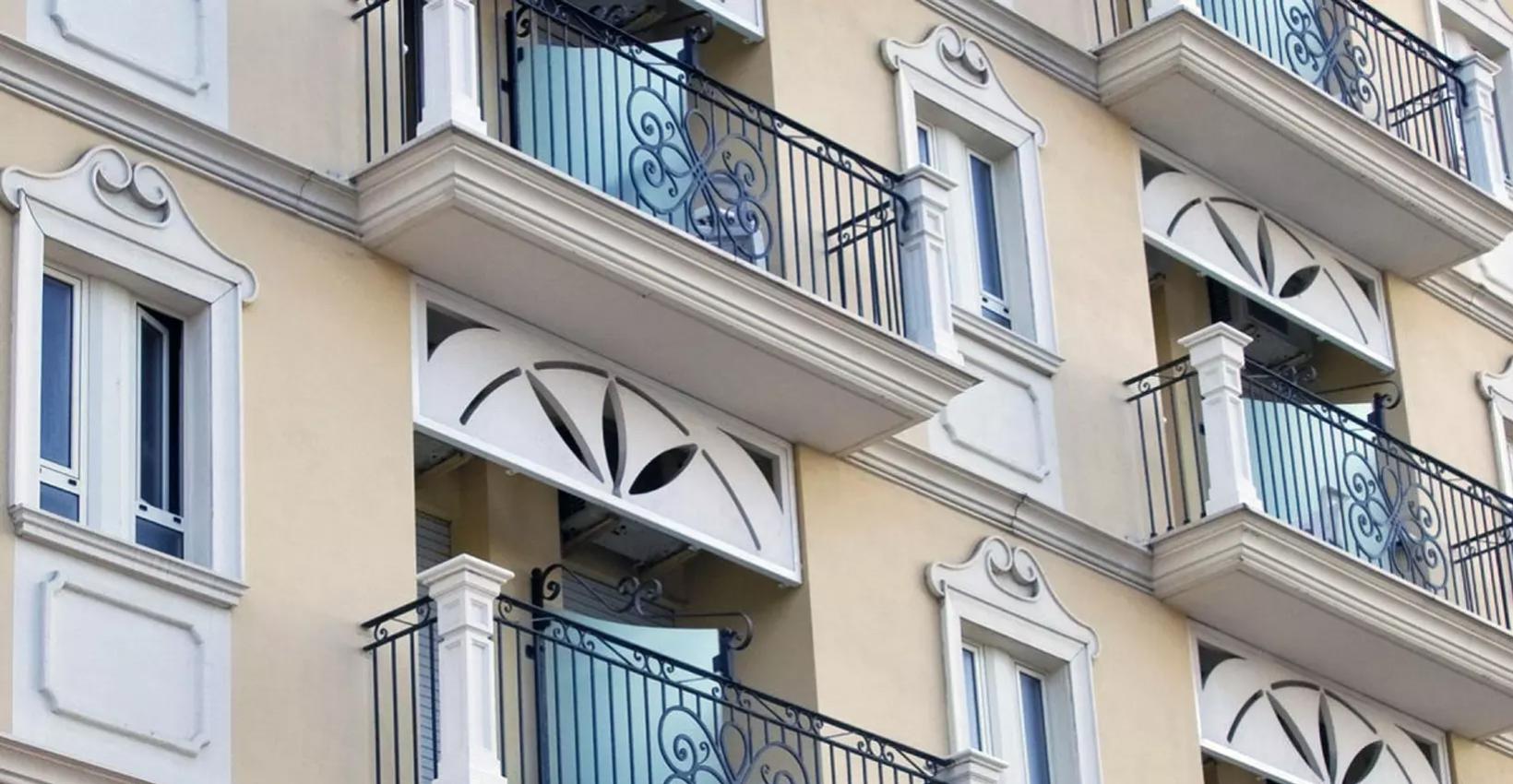 Edificio con balconi in ferro battuto e dettagli ornamentali sulle finestre.