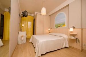 Camera accogliente con letto matrimoniale, arredi chiari e decorazioni semplici.