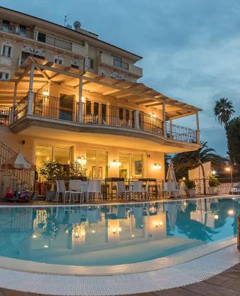 Villa elegante con piscina illuminata, terrazze ampie e atmosfera accogliente al tramonto.