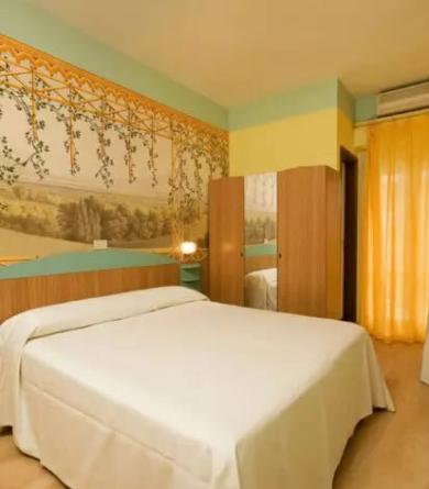 Camera da letto luminosa con letto matrimoniale e decorazioni murali.