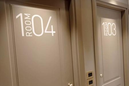 Porte di stanze d'albergo numerate 104 e 103 con scritta 'ROOM'.