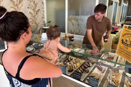 Mother and child choosing pastries in a cozy, bright bakery.