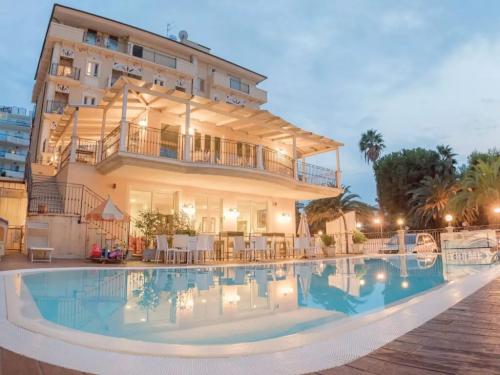 Elegante villa con piscina, terrazza illuminata e palme, atmosfera serena e accogliente.