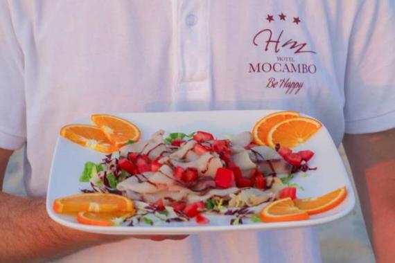 Due cocktail colorati con ghiaccio e limone su un tavolo all'aperto, atmosfera estiva.