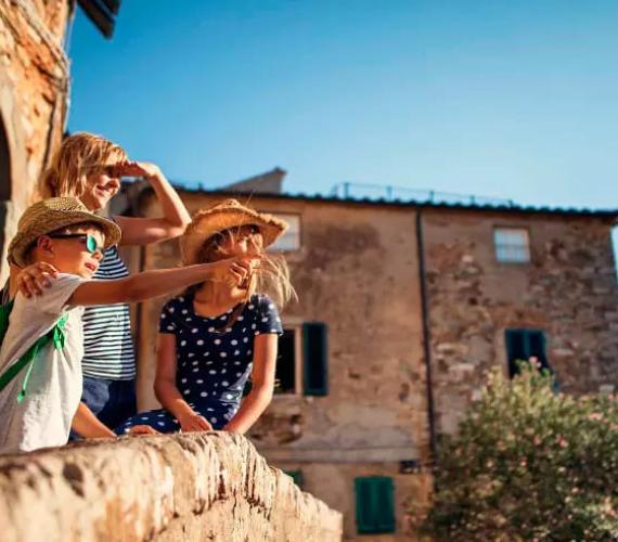 Bambini su un balcone, ammirano il paesaggio in una giornata soleggiata.