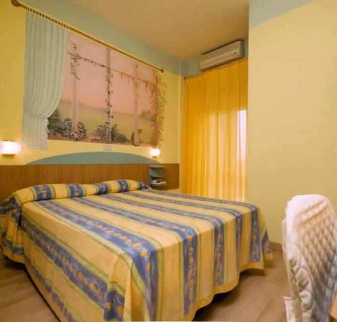 Camera da letto con letto matrimoniale, tende gialle e decorazioni murali.