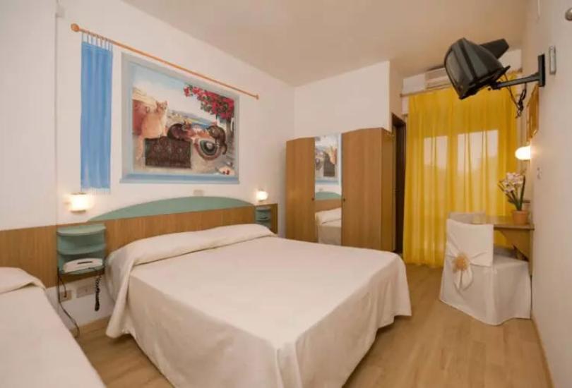 Camera accogliente con letto matrimoniale, TV e decorazioni colorate.