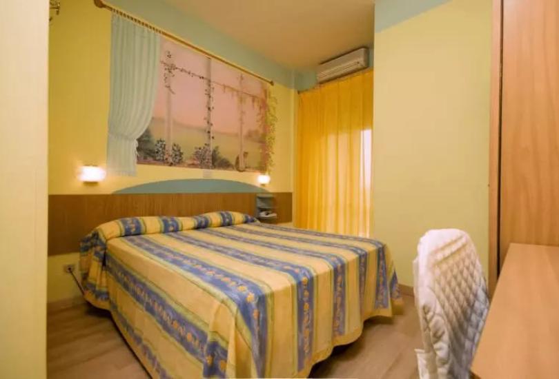 Camera da letto con letto matrimoniale e tende gialle.