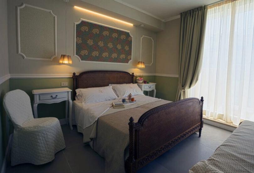 Camera da letto elegante con letto matrimoniale, comodini e decorazioni classiche.
