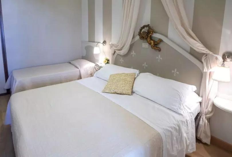 Camera da letto con due letti, decorazioni eleganti e illuminazione soffusa.