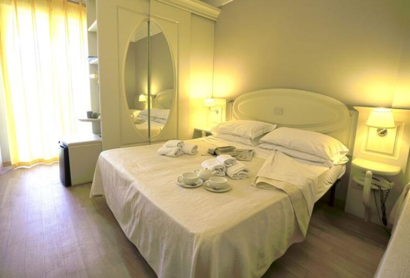 Camera da letto accogliente con letto matrimoniale, tazze e asciugamani su un tavolo.